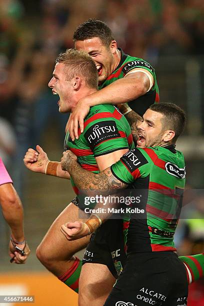 George Burgess of the Rabbitohs is congratulated by his brother Sam Burgess after scoring a try during the 2014 NRL Grand Final match between the...