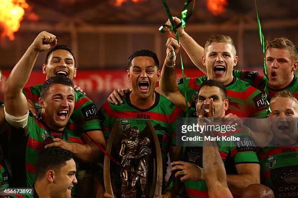 Rabbitohs captain John Sutton celebrates on the podium with his team mates after winning the 2014 NRL Grand Final match between the South Sydney...