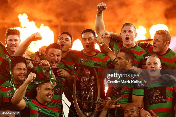 Rabbitohs captain John Sutton celebrates on the podium with his team mates after winning the 2014 NRL Grand Final match between the South Sydney...