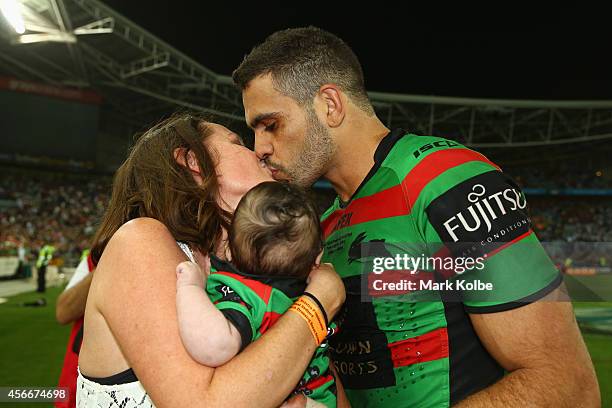 Greg Inglis of the Rabbitohs kisses his wife Sally as she holds their son Nate as celebrates victory during the 2014 NRL Grand Final match between...