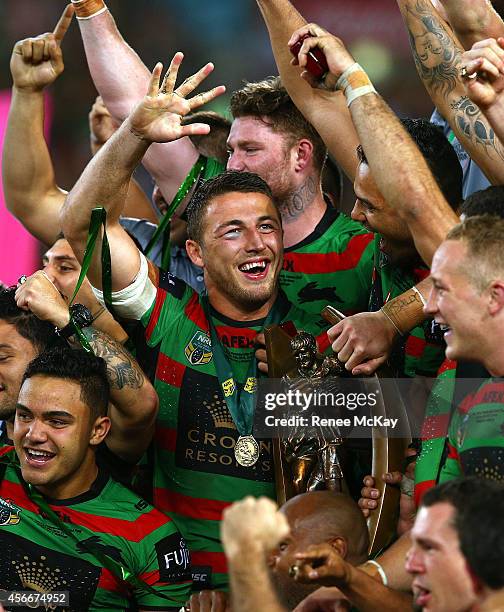 Souths players celebrate with the Provan Summons trophy after their teams win at the 2014 NRL Grand Final match between the South Sydney Rabbitohs...