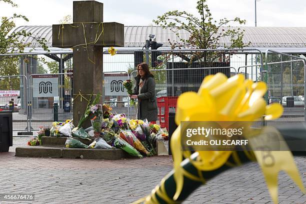 Woman prepares to place a floral tribute at the base of the Eccles Cross for murdered aid worker Alan Henning in Eccles, north west England on...