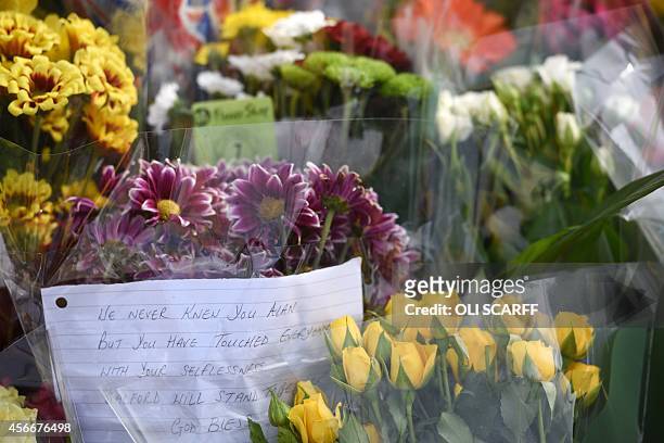 Floral tributes are placed at the base of the Eccles Cross for murdered aid worker Alan Henning in Eccles, north west England on October 5, 2014....