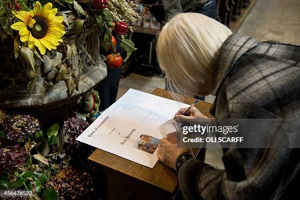 Woman signs the book of condolence in memory of murdered aid worker Alan Henning in Eccles Parish Church in Eccles, north west England on October 5,...