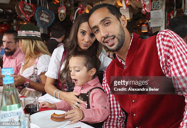 Mehdi Benatia of FC Bayern Muenchen, his wife Cecile and son Kays attend the Oktoberfest 2014 beer festival at Kaefers Wiesenschaenke at...