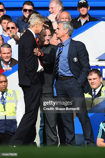 Fourth Official Jonathan Moss comes between Managers Arsene Wenger of Arsenal and Jose Mourinho manager of Chelsea during the Barclays Premier League...