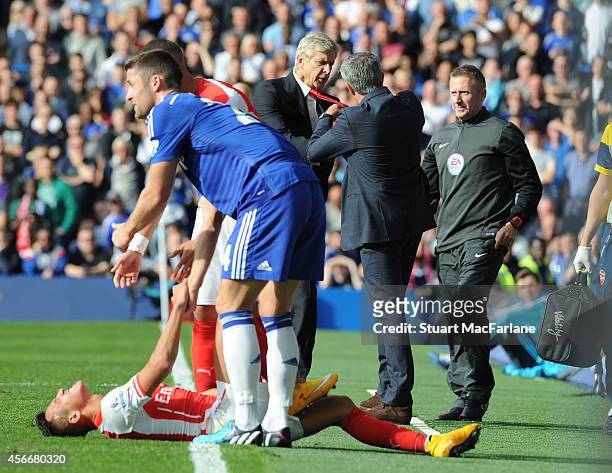 Managers Arsene Wenger of Arsenal and Jose Mourinho of Chelsea clash after a foul on Arsenal's Alexis Sanchez during the Barclays Premier League...