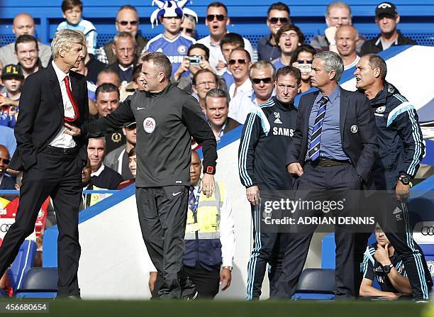 Chelsea's Portuguese manager Jose Mourinho and Arsenal's French manager Arsene Wenger are kept apart by the fourth official Jonathan Moss during the...