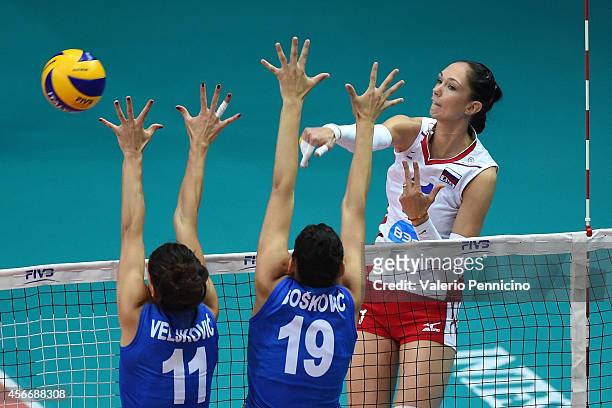 Ekaterina Gamova of Russia spikes as Tijana Boskovic and Stefana Veljkovic of Serbia block during the FIVB Women's World Championship pool F match...