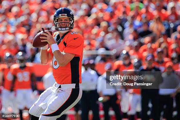 Quarterback Peyton Manning of the Denver Broncos drops back to pass what would be his 500th career touchdown pass to Julius Thomas in the first...