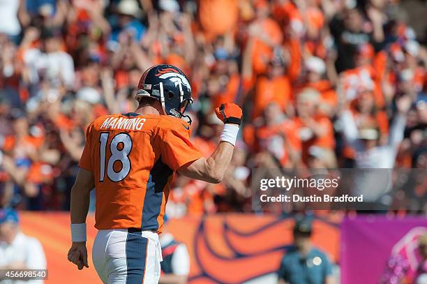 Quarterback Peyton Manning of the Denver Broncos celebrates after passing his 500th career touchdown pass to Julius Thomas in the first quarter of a...