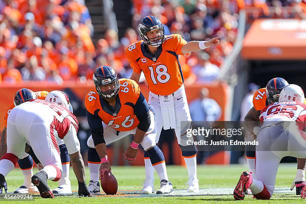 Quarterback Peyton Manning of the Denver Broncos runs the offense as center Manny Ramirez waits to snap the ball int he first quarter of a game...