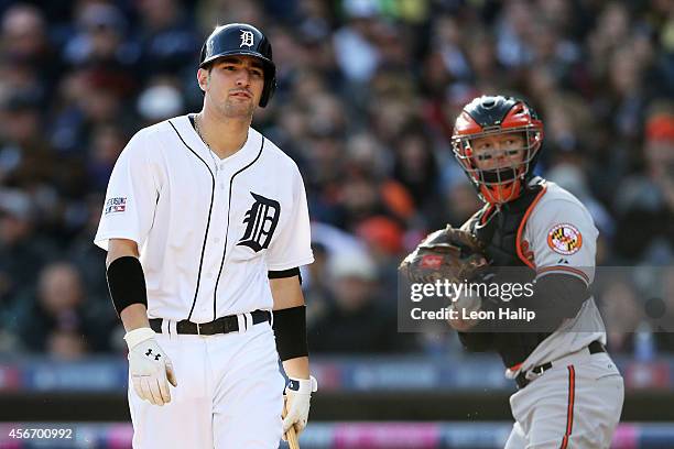 Nick Castellanos of the Detroit Tigers reacts as he strikes out to end the fourth inning as Nick Hundley of the Baltimore Orioles looks on during...