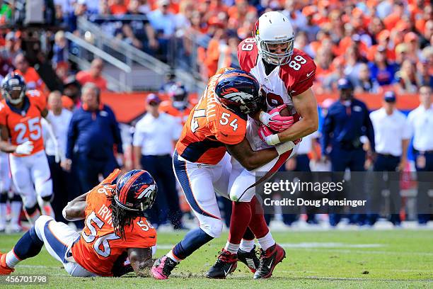 Tight end John Carlson of the Arizona Cardinals is tackled by outside linebacker Brandon Marshall of the Denver Broncos during a game at Sports...