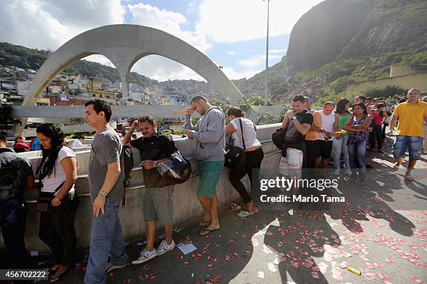 Brazilians wait in line to enter a polling station in the Rocinha favela, or community, on the day of national elections on October 5, 2014 in Rio de...