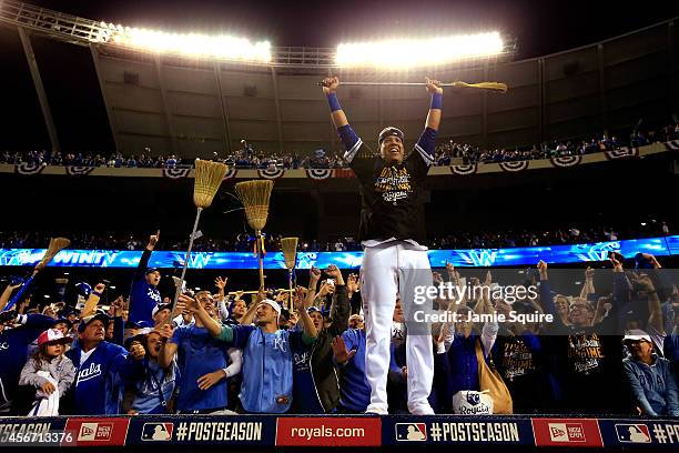 Salvador Perez of the Kansas City Royals celebrates with fans on top of the dugout after the Royals defeated the Los Angeles Angels 9-3 to win game 3...