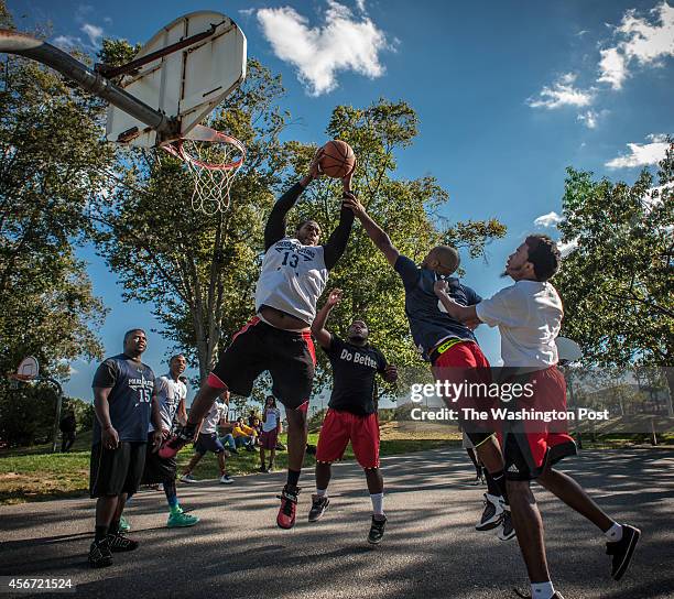 Ofc. Terrence Garrett, PGPD, pulls down a rebound as Do Better President, Gregory Brown , Ofc. Calvin Brinkley , and Colin Byrd, with the campus BSU...