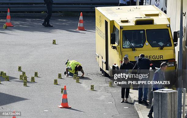 French forensic experts work on Prosegur's armoured truck attacked this morning by a commando on October 6, 2014 in a gas station on the A47 motorway...