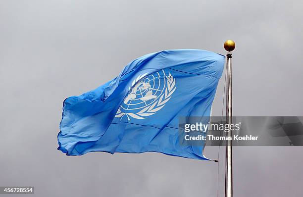 Flag of the United Nations in front of grey clouds on top of the United Nations Secretariat at the headquarters of the United Nations on September 24...