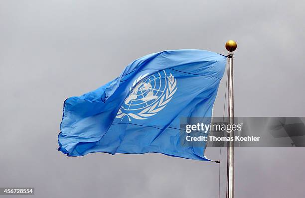 Flag of the United Nations in front of grey clouds on top of the United Nations Secretariat at the headquarters of the United Nations on September 24...