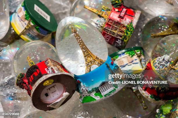 Eiffel tower snowglobes are displayed in a souvenir shop on the first floor of the Eiffel Tower in Paris on August 5, 2014. AFP PHOTO LIONEL...