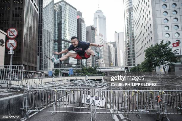 Man jumps from a barricade of pro-democracy demonstrators in Hong Kong on October 6, 2014. Exhausted Hong Kong demonstrators debated the next step in...