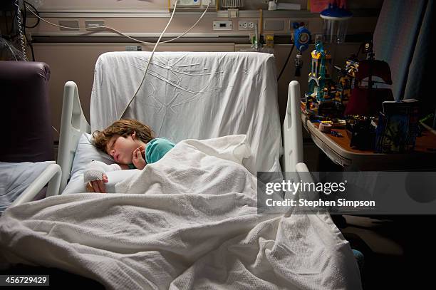 sleeping boy w/toys in hospital burn unit - solo bambini maschi foto e immagini stock