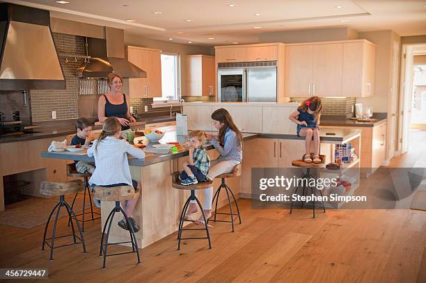 family having snacks on the kitchen "island" - family with five children stock pictures, royalty-free photos & images