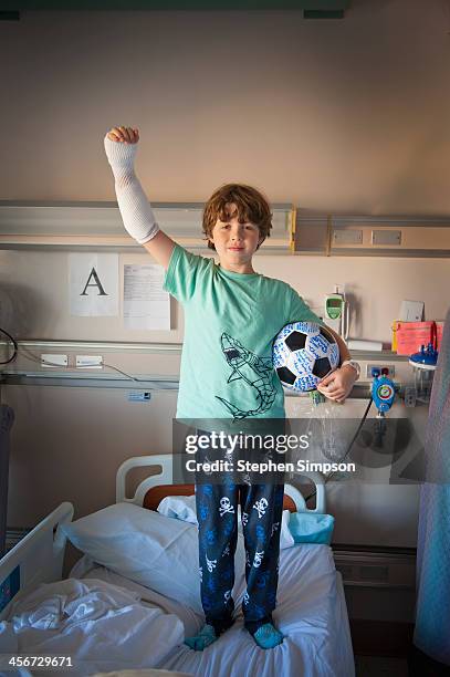 boy in hospital burn unit with soccer ball - cast stockfoto's en -beelden