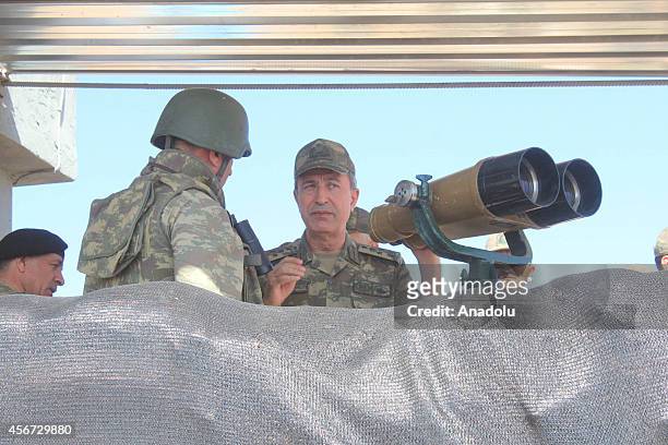 Turkish Land Forces Commander General Hulusi Akar appraises the situation on the Syrian border as a Turkish soldier informs him about the clashes in...