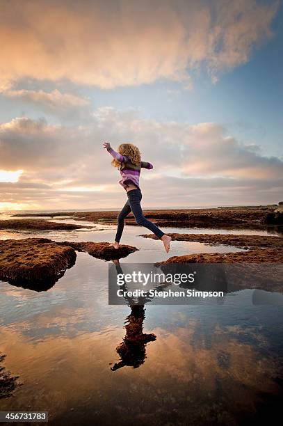 teen girl leaping over tide pools - san diego people stock pictures, royalty-free photos & images