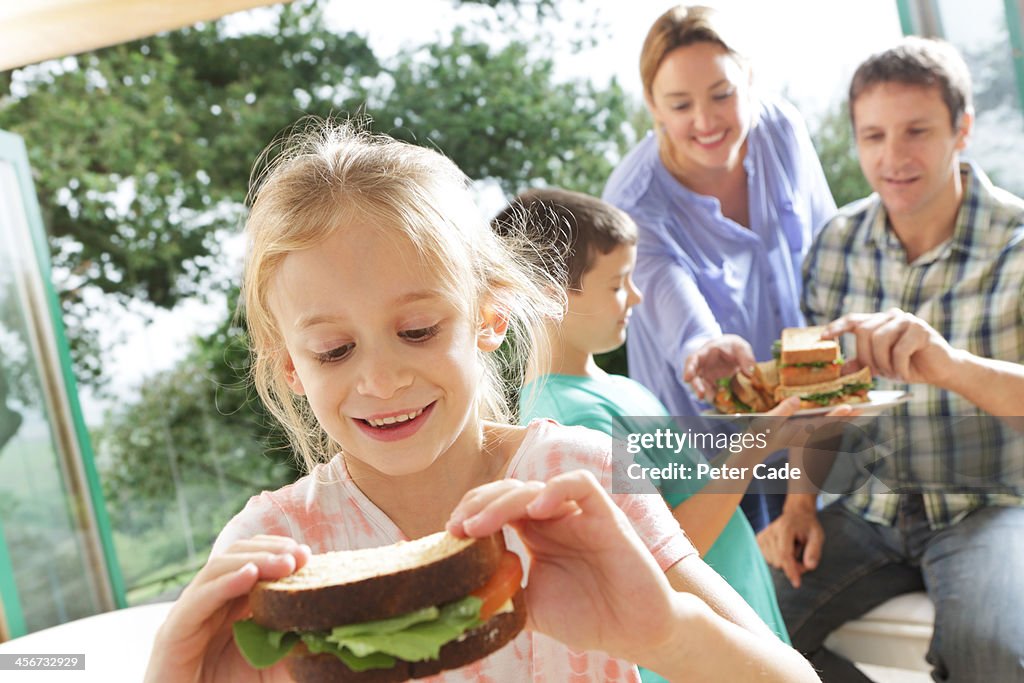 Family eating sandwiches, girl close to camera