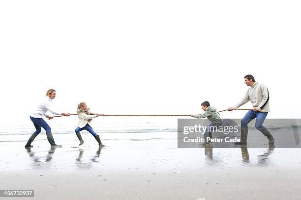 Family On Beach Playing Tug Of War, Foto de stock