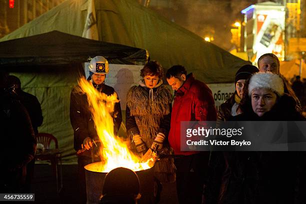 Protesters warm themselves while standing in Maidan Square on December 14, 2013 in Kiev, Ukraine. Anti-government protests began three weeks ago when...