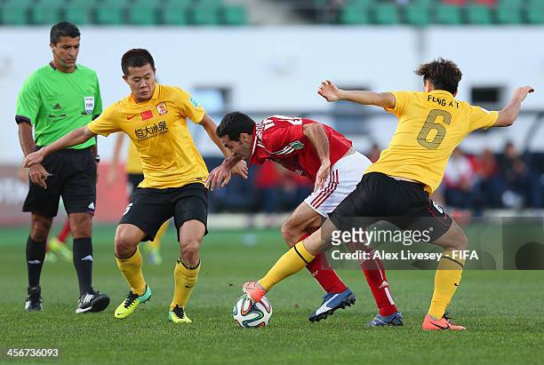 Mohamed Aboutrika of Al-Ahly SC is tackled by Xiaoting Feng of Guangzhou Evergrande FC during the FIFA Club World Cup Quarter Final match between...