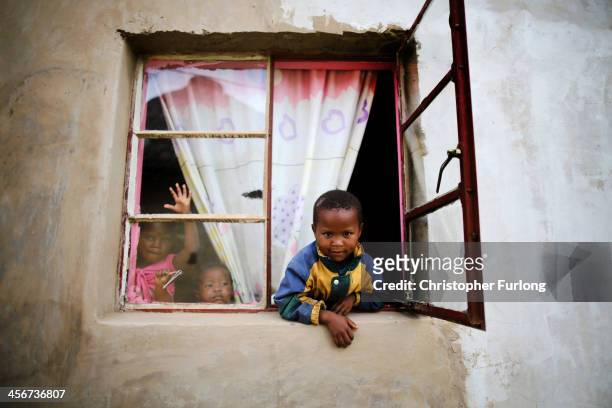 Young children peer from the window to watch the funeral of former South African President Nelson Mandela in his home village of Qunu on December 15,...