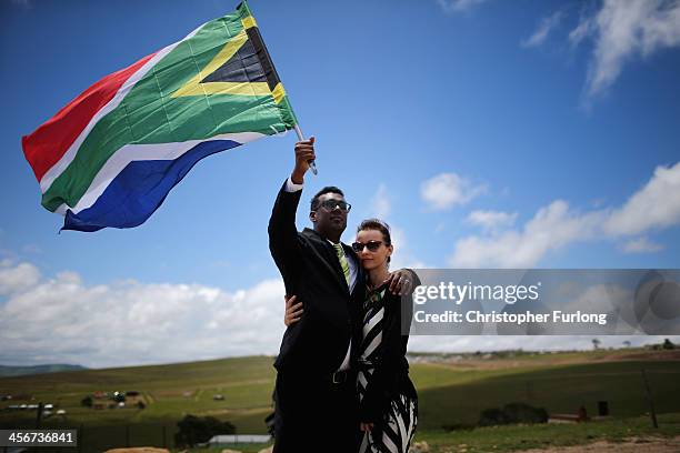 Karlind Govender and his wife Katharina, of Cape Town overlook the burial site as a 21 gun salute is fired in honour of former South African...