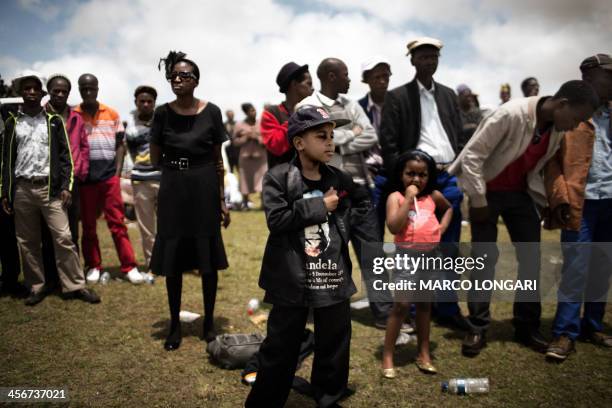 South African people watch from a hill the state funeral of South African President Nelson Mandela in Qunu on December 15, 2013. Mandela, the revered...