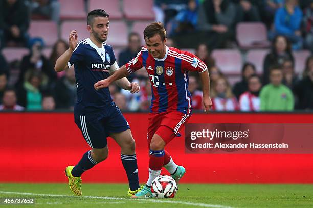 Mario Goetze of Muenchen battles for the ball with Peter Kollmann of Paulaner Traumelf during the Finale of the Paulaner Cup 2014 between FC Bayern...