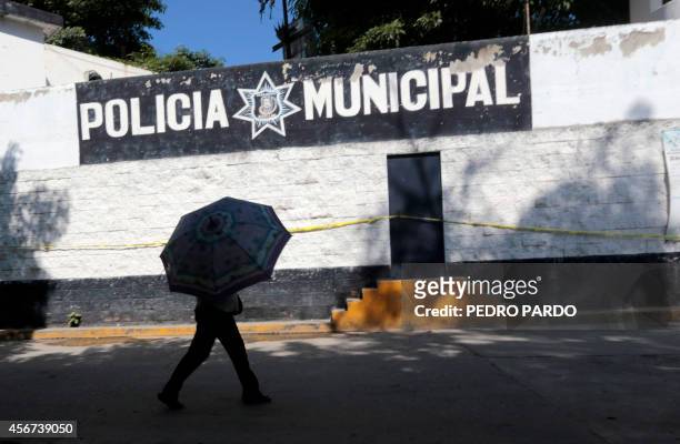 Woman walks by the empty barracks of the municipal police whose members are flagged to collaborate with the organized crime in Iguala, Guerrero...