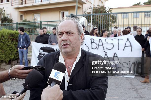 Corsican nationalist militant Jean-Marie Poli speaks to journalists while around fifty people gather with nationalist flags in front of Aspretto...