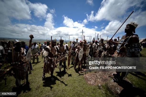 Zulu tribe members celebrate as the coffin of South African former President Nelson Mandela is carried to his burial site during his state funeral in...