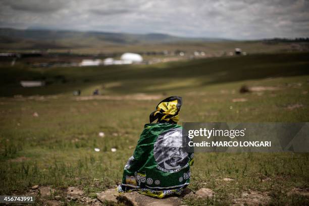 Woman looks on as South African former president Nelson Mandela's coffin is carried to his burial site during his state funeral in Qunu on December...