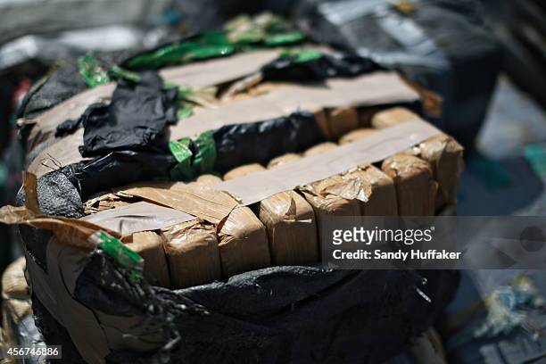 Piles of confiscated cocaine, seized during a 18 different interdictions off the coast of Central and South America, is prepared to be offloaded from...