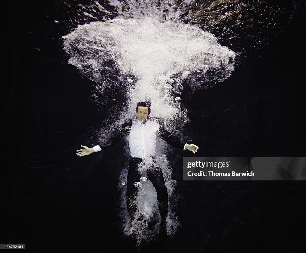 Businessman in suit plunging into water