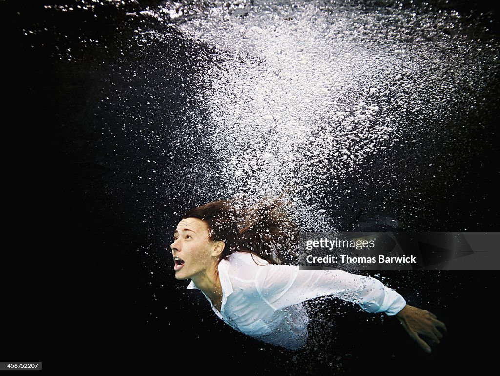 Businesswoman underwater screaming