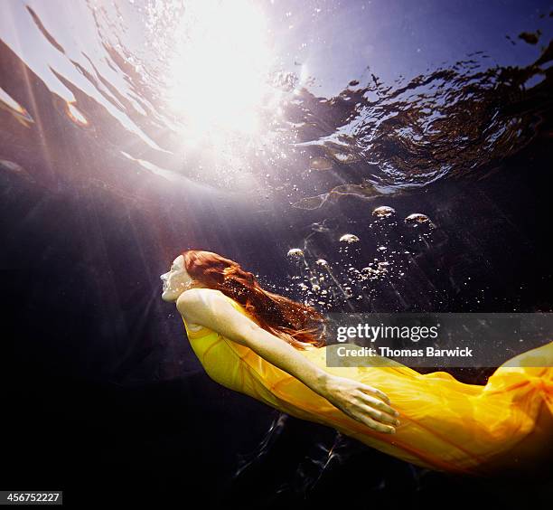 Underwater view of woman swimming to surface