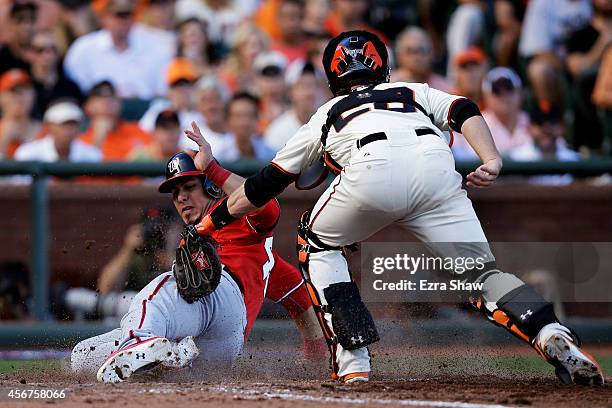 Wilson Ramos of the Washington Nationals scores on a single by Asdrubal Cabrera as Buster Posey of the San Francisco Giants tries to make the tag in...