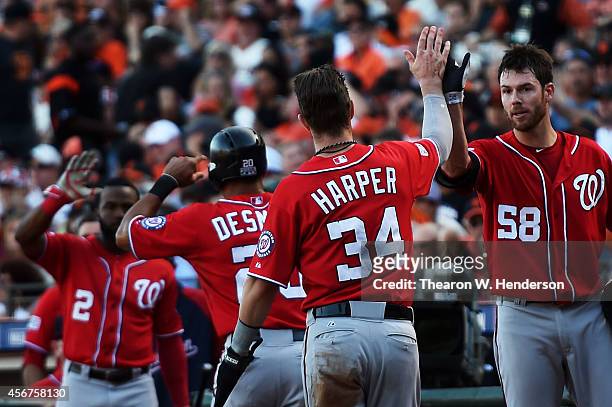 Bryce Harper and Ian Desmond of the Washington Nationals celebrate with teammates Doug Fister and Denard Span after they scored in the seventh inning...