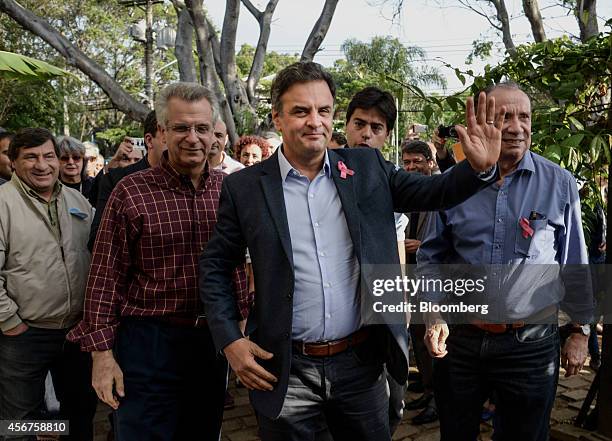 Aecio Neves, presidential candidate for the Brazilian Social Democracy Party, known as PSDB, center, waves while arriving for a news conference in...